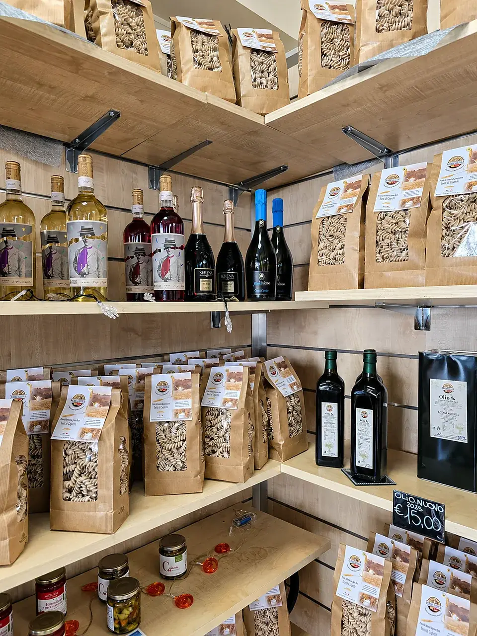 Scaffali del punto vendita con olio extravergine, pasta e farine aziendali